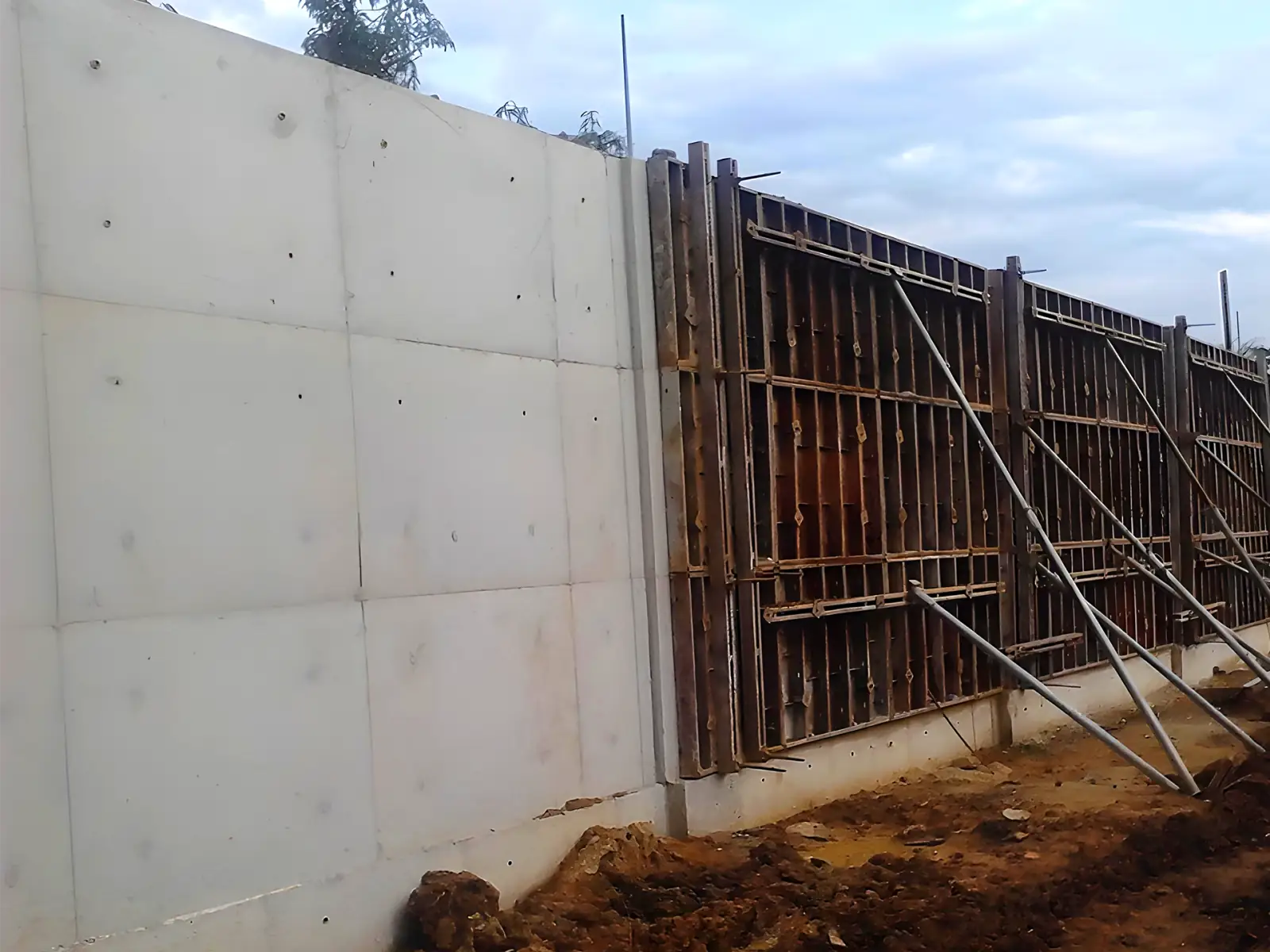 Locação de formas e escoramentos metálicos Muro de concreto aparente executado com formas metálicas da SP Formas